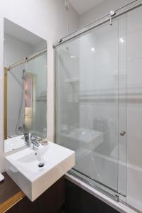 uma casa de banho com um lavatório e um chuveiro em Guest House Douro em Porto