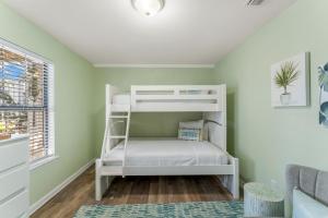 Ce lit superposé blanc se trouve dans un dortoir aux murs verts. dans l'établissement Solitude on 30A - Seacrest Beach Townhouse with Beach Access - FREE BIKES, à Rosemary Beach
