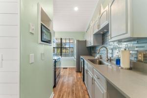 a kitchen with white cabinets and a sink at Solitude on 30A - Seacrest Beach Townhouse with Beach Access - FREE BIKES in Rosemary Beach