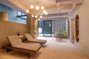 sala de estar con 2 sillas y lámpara de araña en Acogedor apartamento con piscina en Bogotá, en Bogotá