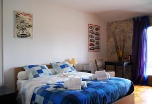 a bedroom with a blue and white bed with towels on it at Chez Catharina Oldtimer B&B in Levoncourt