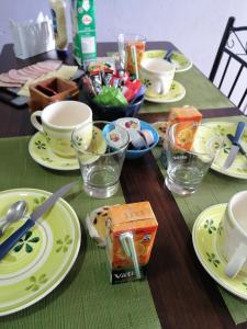 un tavolo con piatti e tazze gialli sopra di Casa Celeste a Punta Arenas
