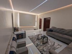 a living room with a couch and a table at Madina Luxe Apartments - 7 minutes to Haram by Car - Mount Uhud Views - Free Parking - Kitchen in Al Madinah