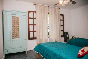 Un dormitorio con una cama azul y una ventana en Complejo Bolivar en Mina Clavero
