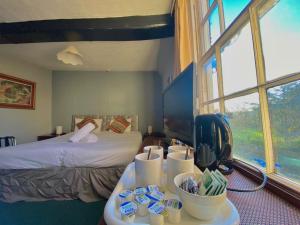 um quarto de hotel com uma cama e uma mesa com copos em Greyfriars Lodge Canterbury em Canterbury