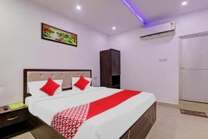 a bedroom with a large bed with red pillows at Collection O Hotel Prime A-One Inn Near Chaudhary Charan Singh International Airport in Bijnaur