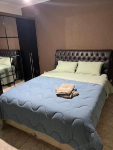 uma cama com um cobertor azul e uma cabeceira preta em GA4-Hospedagem Próximo ao Aeroporto de Guarulhos em Guarulhos