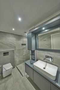 ein Badezimmer mit einem Waschbecken, einem WC und einem Spiegel in der Unterkunft Villa Rio in Kalkan