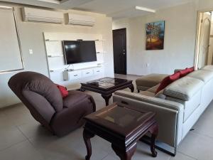 sala de estar con 2 sofás y TV en Departamento Lomas de Rosales, en Tampico