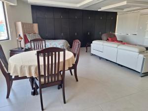 a bedroom with a bed and a table and chairs at Departamento Lomas de Rosales in Tampico