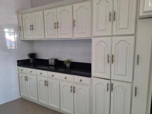 a kitchen with white cabinets and a black counter top at Departamento Lomas de Rosales in Tampico