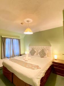 a bedroom with a large white bed with a green wall at Greyfriars Lodge Canterbury in Canterbury
