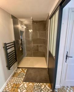 eine ebenerdige Dusche in einem Zimmer mit Tür in der Unterkunft Les Terrasses des Antiques 2 in Saint-Rémy-de-Provence