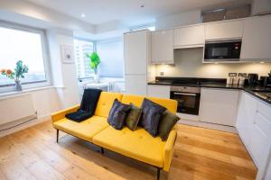 a yellow couch with pillows on it in a kitchen at Cosy 2 Bed Apartment, East Croydon in Croydon