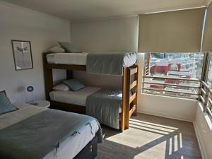 a room with two bunk beds and a window at Espectacular Bahía Bonita depto 41 in Concón