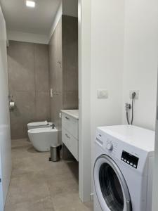 a bathroom with a washing machine and a toilet at Ambra House in Trezzano sul Naviglio