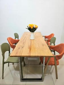 a wooden table with a vase of flowers on it at Air-home No 28 Simpang near Aulong Econsave, 3BR, 7pax, Netflix in Simpang
