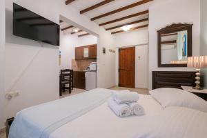 a bedroom with a white bed with towels on it at Afrodite Hotel Apartments in Myrina