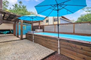 uma piscina com dois guarda-sóis azuis ao lado em Serenity - A Birdy Vacation Rental em San Antonio