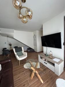 sala de estar con TV de pantalla plana en la pared en Golden Gondola Tornik, en Zlatibor