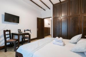 a bedroom with a bed and a desk and a television at Afrodite Hotel Apartments in Myrina