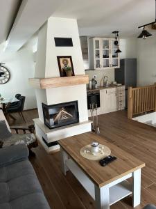 a living room with a fireplace and a table at Golden Gondola Tornik in Zlatibor