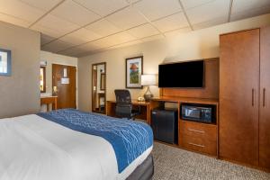 Habitación de hotel con cama y TV de pantalla plana. en Comfort Inn & Suites Gateway to Glacier National Park, en Shelby