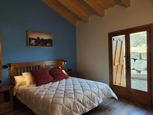 a bedroom with a bed with red pillows on it at LAS BORDAS DE MIQUELET in Viacamp +55 photos