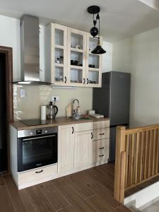 a kitchen with white cabinets and a black microwave at Golden Gondola Tornik in Zlatibor