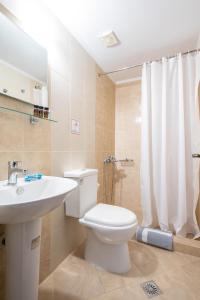 a bathroom with a white toilet and a sink at Afrodite Hotel Apartments in Myrina