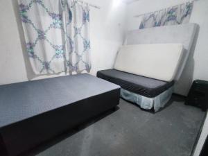 a small room with two beds and a chair at Casa aconchego com piscina in Guaratuba +3 photos