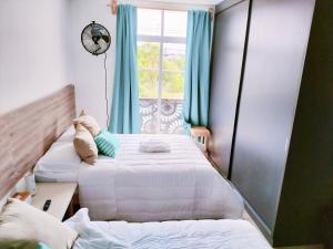 two beds in a room with a window at Aqua Suites in Oaxaca City