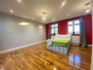 a bedroom with a bed and a red wall at Massive Studio with Garden In Leafy Canary Wharf Docklands Retreat in London
