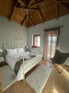 a bedroom with a white bed and a chair at Country Stone House ,next to Kalavrita in Kalavrita