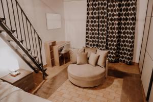 un soggiorno con sedia e scala di Appartamento - Grammichele Privitera rooms & apartments Gold a Grammichele