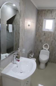 uma casa de banho com um lavatório branco e um WC. em Glaciar Union em Punta Arenas