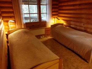 TapioにあるAapishovi Chaletのログキャビン内のベッドルーム1室(ベッド2台付)