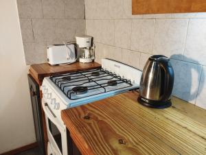 a kitchen with a stove and a coffee pot on a counter at Home Casa Julio in Villa La Angostura