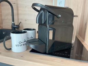 a coffee maker sitting on a counter with two coffee cups at STAYWELL I Südstadt Für 4 I CO2 Free in Paderborn