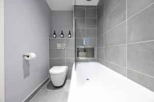 a bathroom with a white toilet and a sink at Luxury Apartment by Ocean Village Marina in Southampton