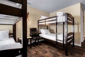 a room with bunk beds with a desk and a chair at Speakeasy - A Birdy Vacation Rental in San Antonio