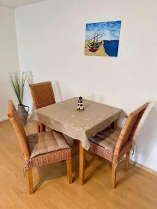 a dining room table with chairs and a picture of a boat at Ferienwohnung Flunder in Zempin