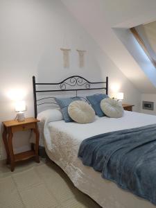 a bedroom with a large bed with blue pillows at Piso Beiramar in Pontevedra