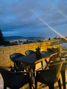 uma mesa e cadeiras de madeira com vista para a cidade em Casa Onésima. Departamento privado con Terraza. em Oaxaca de Juárez