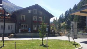 ein schwarzes Gebäude mit Bäumen davor in der Unterkunft Alpine Budget Rooms by Täscherhof in Täsch