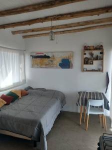 a bedroom with a bed and a chair in it at Mandalei, Refugio De Mar in Las Grutas