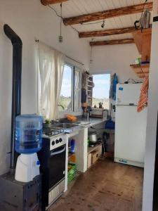 a kitchen with a stove and a refrigerator at Mandalei, Refugio De Mar in Las Grutas