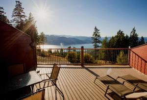 a deck with a view of a lake and mountains at Crooked Tree Guest Suites in Penticton