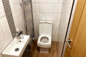 een kleine badkamer met een toilet en een wastafel bij Boss Breaks-Luton in Luton