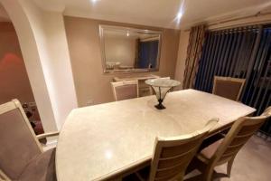 a dining room with a white table and chairs at Boss Breaks-Luton in Luton